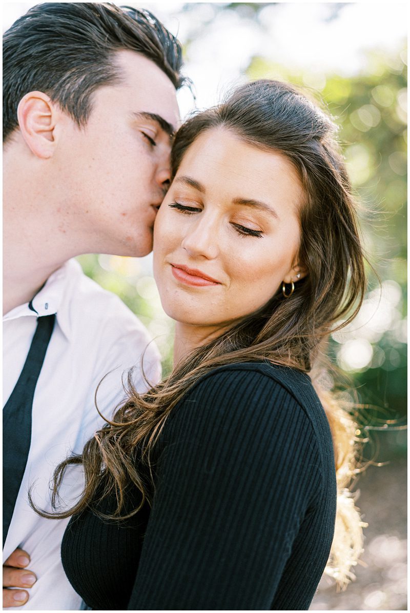 romantic engagement photo in Charleston of guy kissing the girls cheek