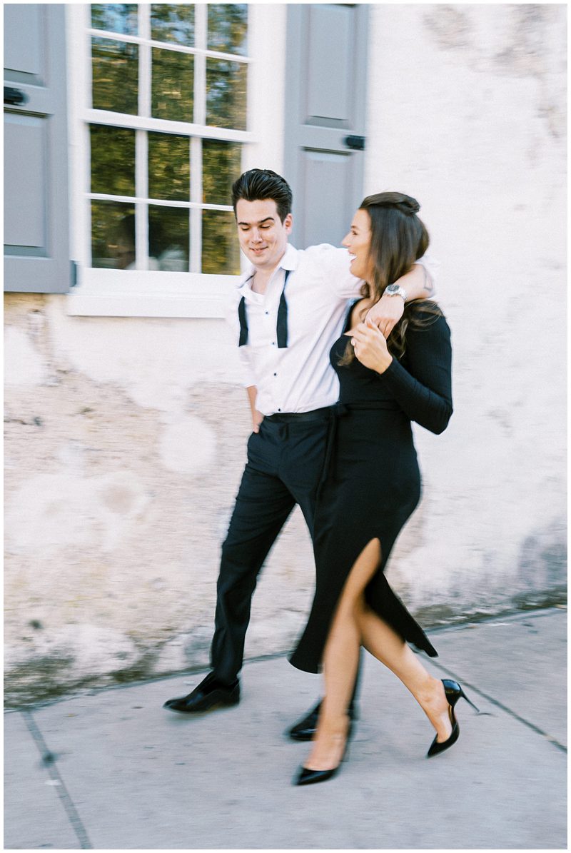 couple casually walking in downtown Charleston at their engagement session