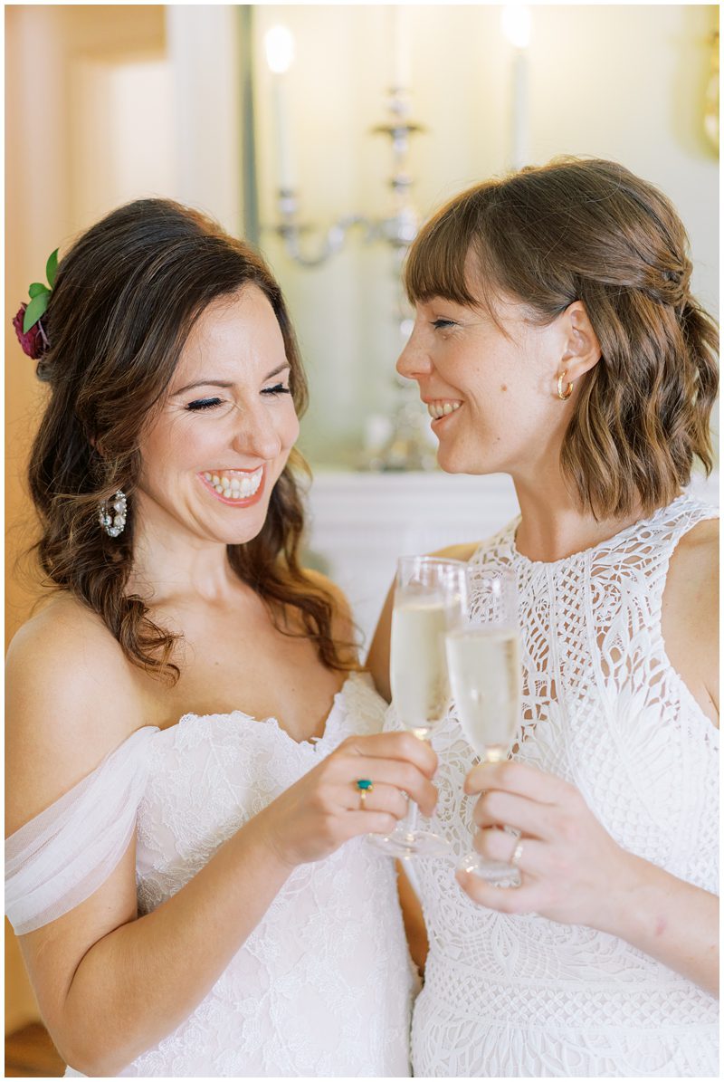 two brides toasting champagne at their wedding