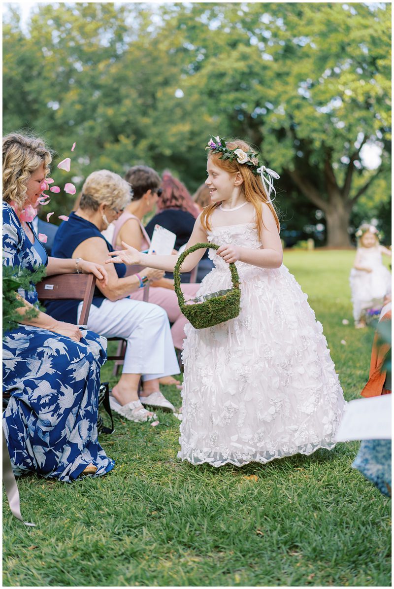 adorable photo of flower girl tossing petals at people