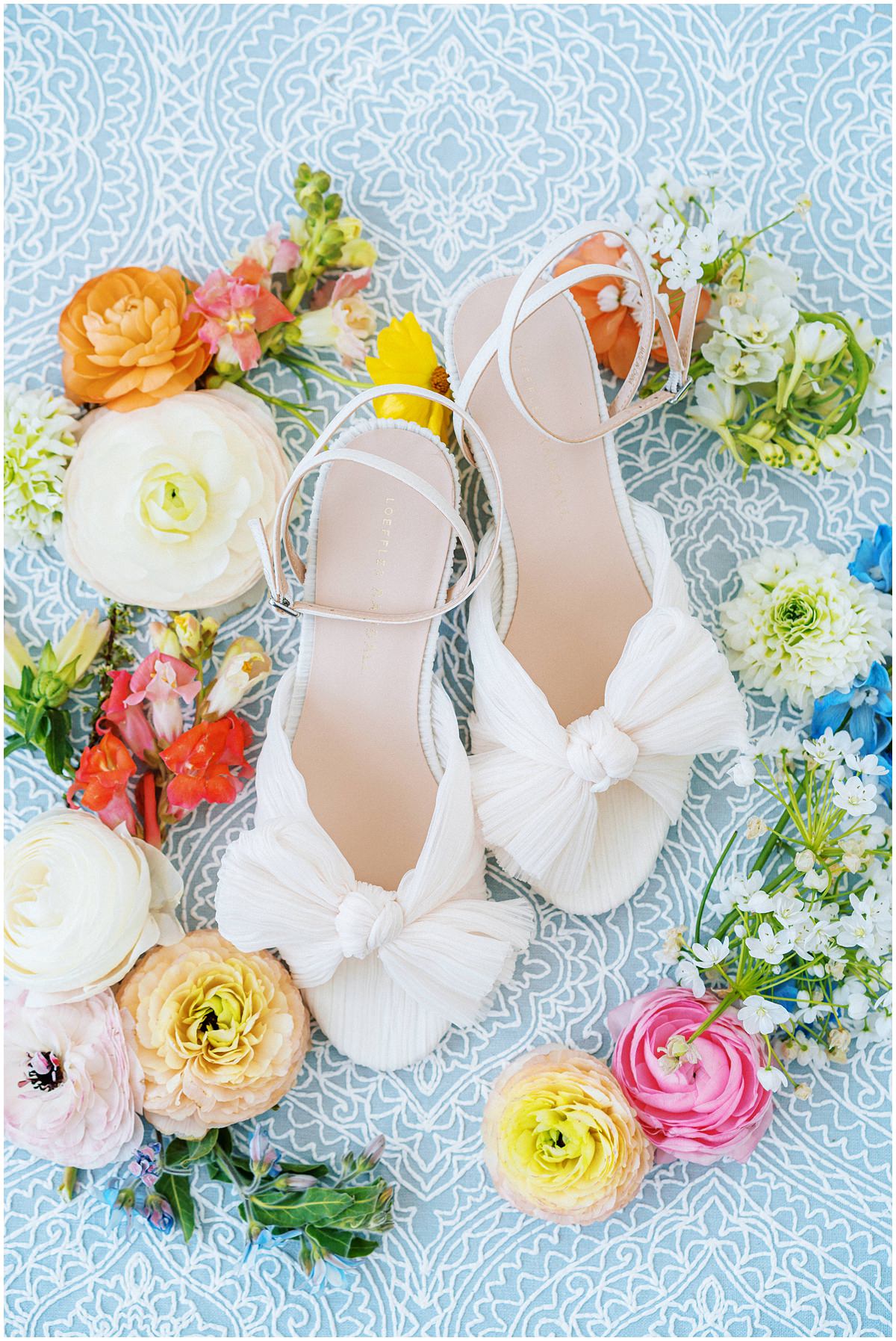 white loeffler randall bridal shoes surrounded by colorful flowers
