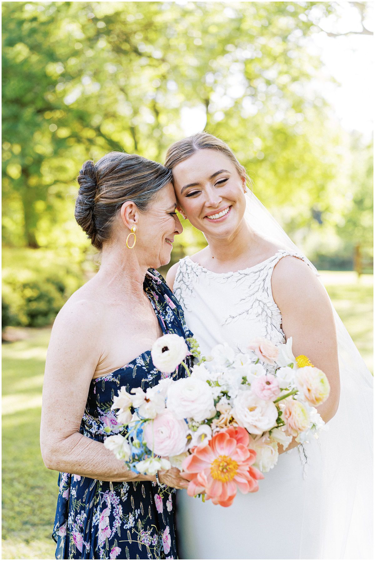 candid photo of bride and her mom touching heads together