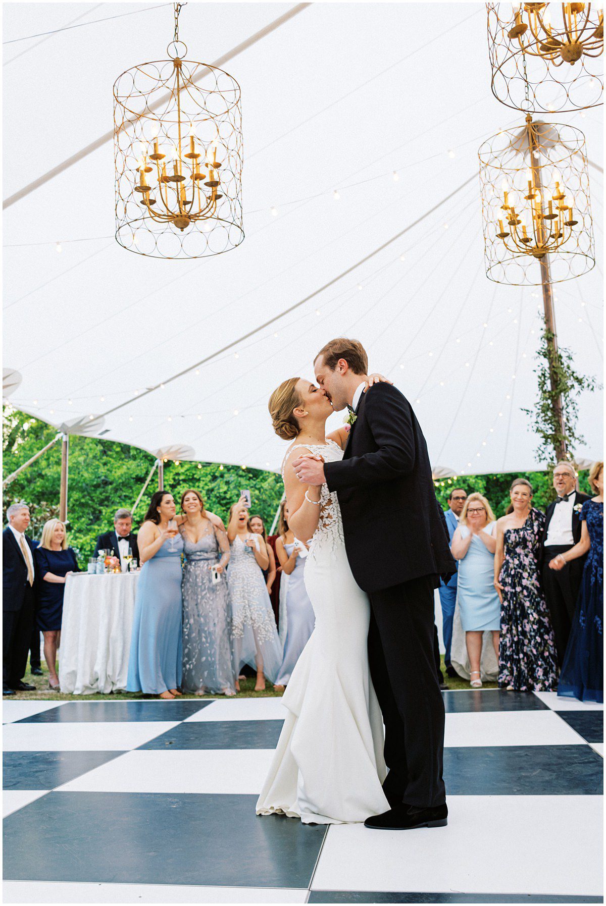 bride and groom sharing their first dance under a sail cloth tent and checkered dance floor at Wavering Place