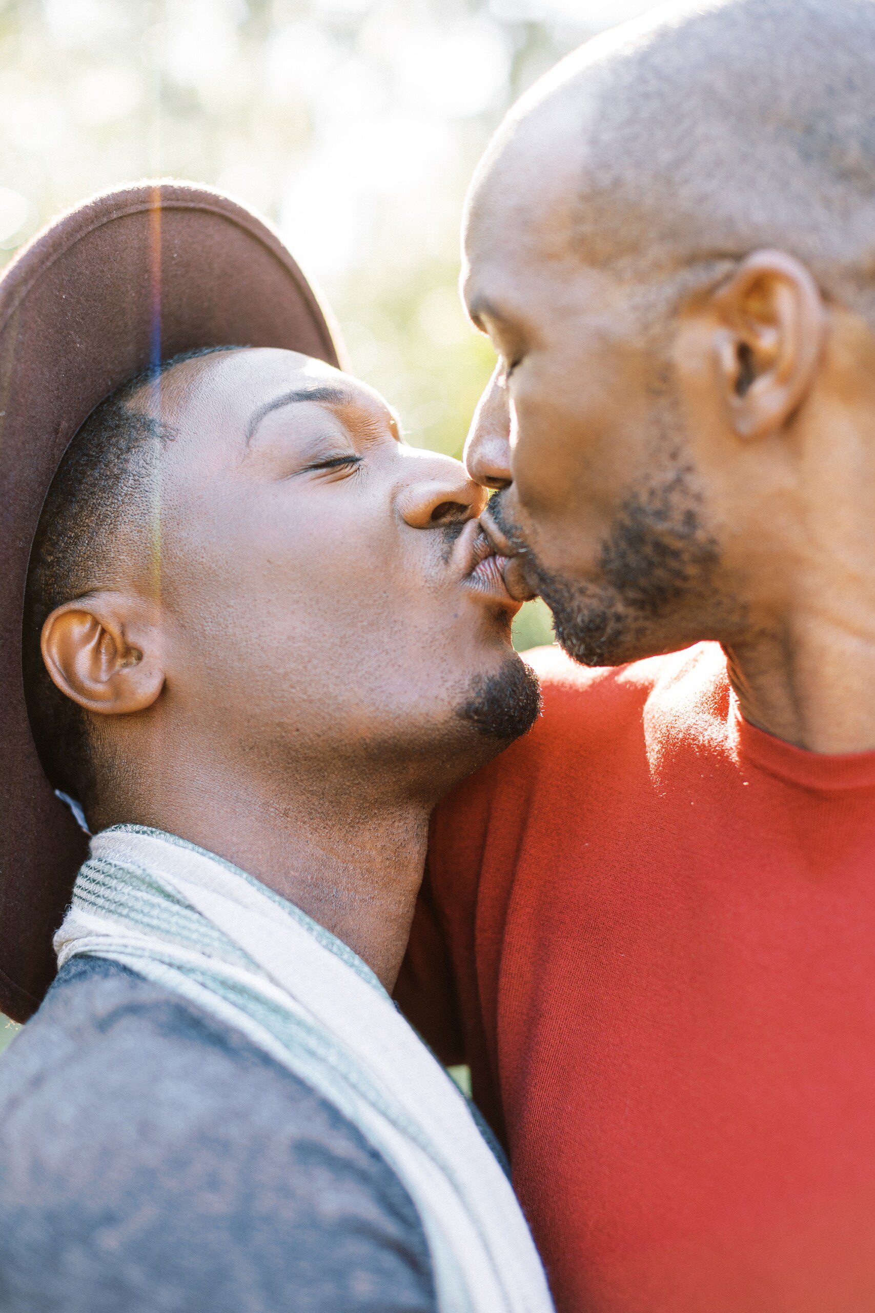 Two black men kissing at their LGBTQ engagement session at Middleton Place