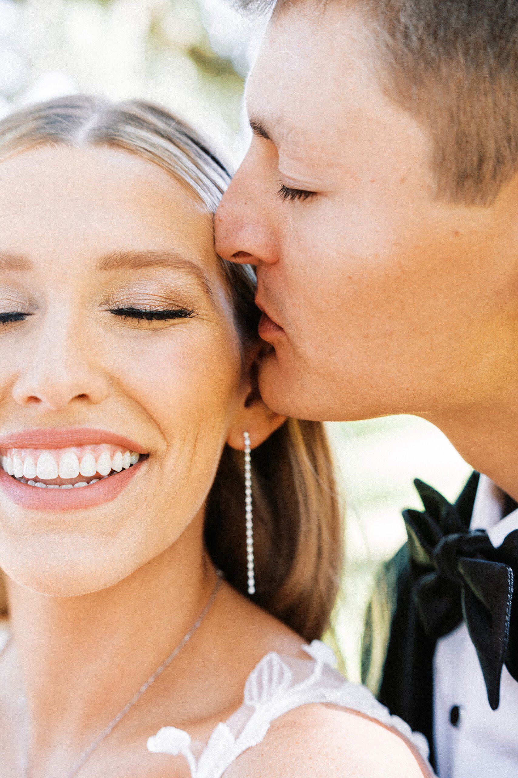 Close up romantic wedding portrait at Middleton Place of the groom kissing the brides temple