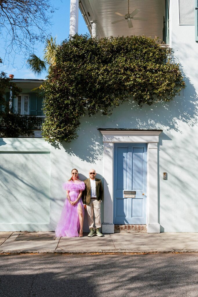 Girl wearing tulle purple gown and guy wearing moss green suit at their engagement session at Rainbow Row in Charleston