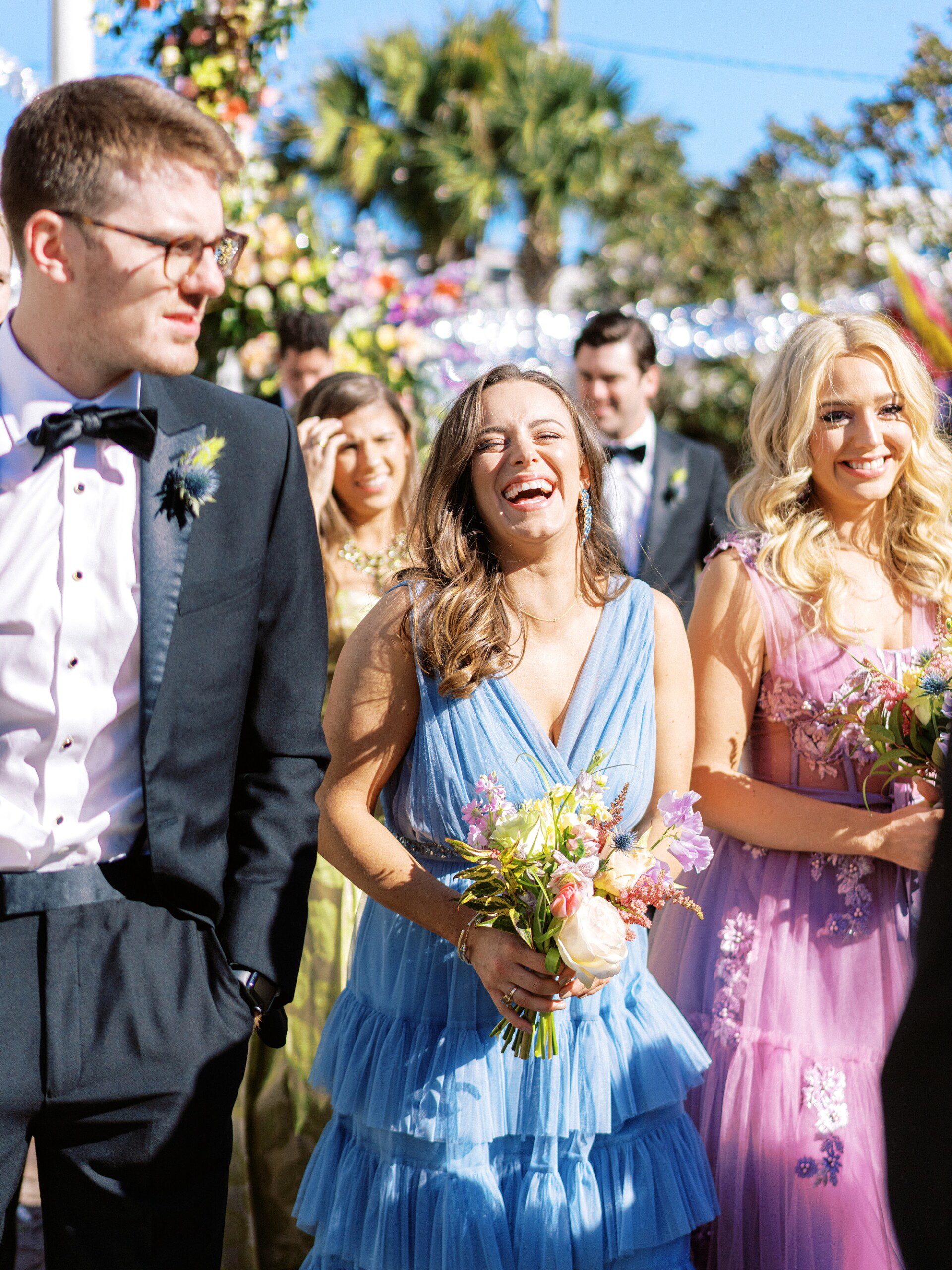 Candid image of a very fashionable bridesmaid laughing with a groomsman at a Charleston wedding