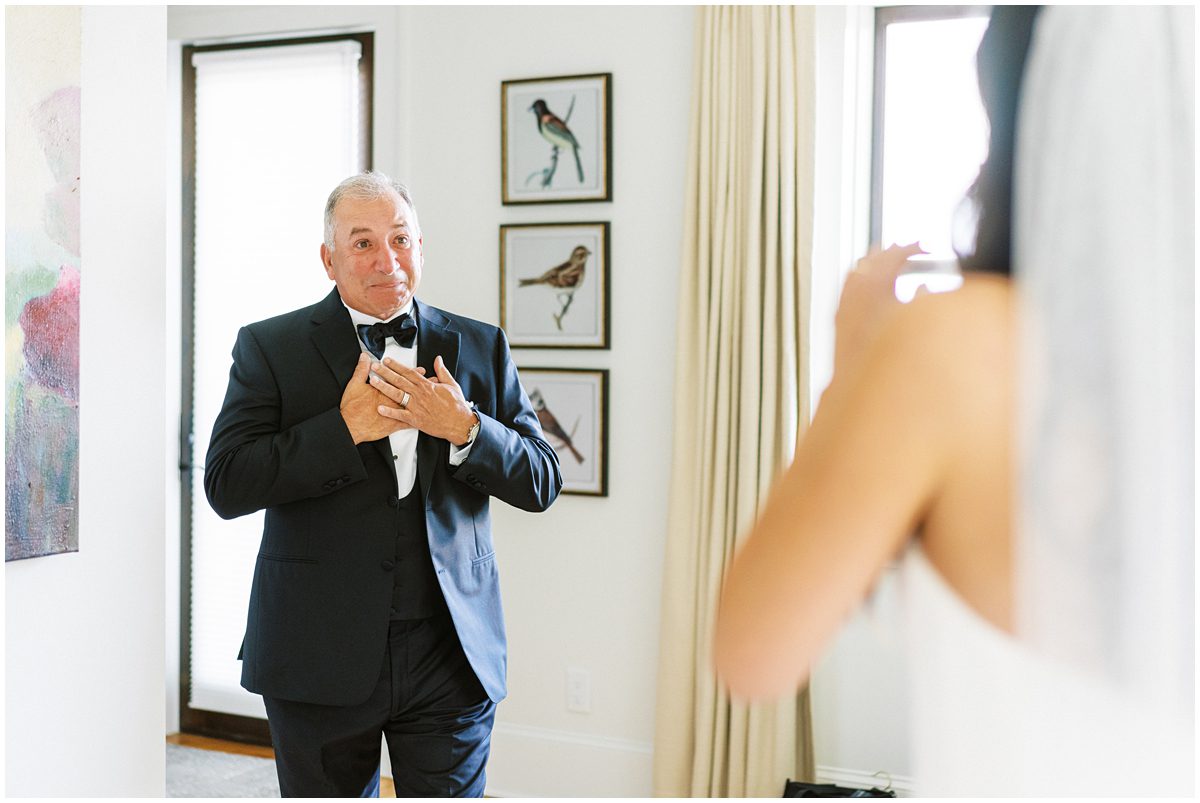 Emotional father of the bride sheds tears during their first look on the wedding day.