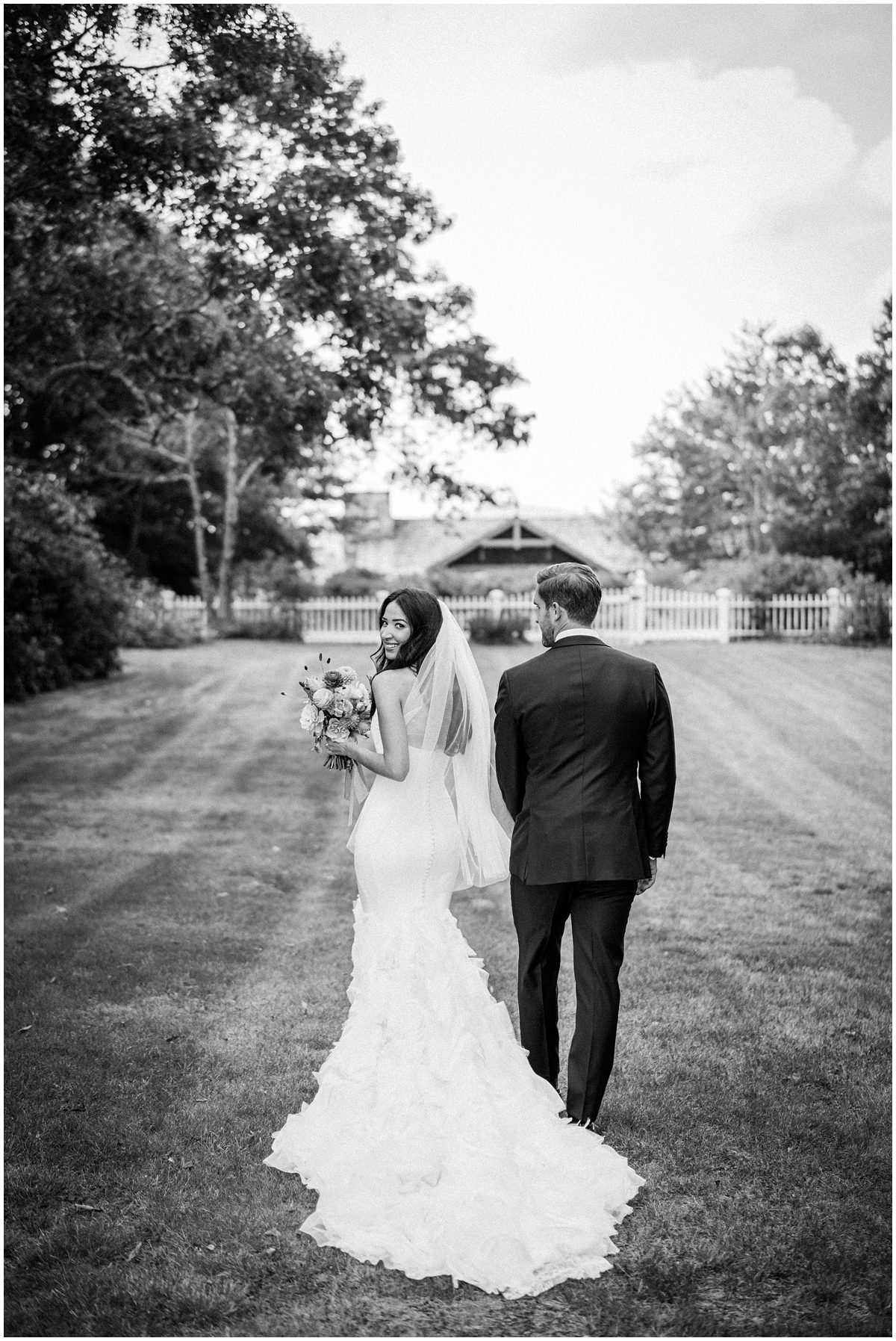 The bride stuns in a form-fitting mermaid gown while the groom rocks a sleek black suit