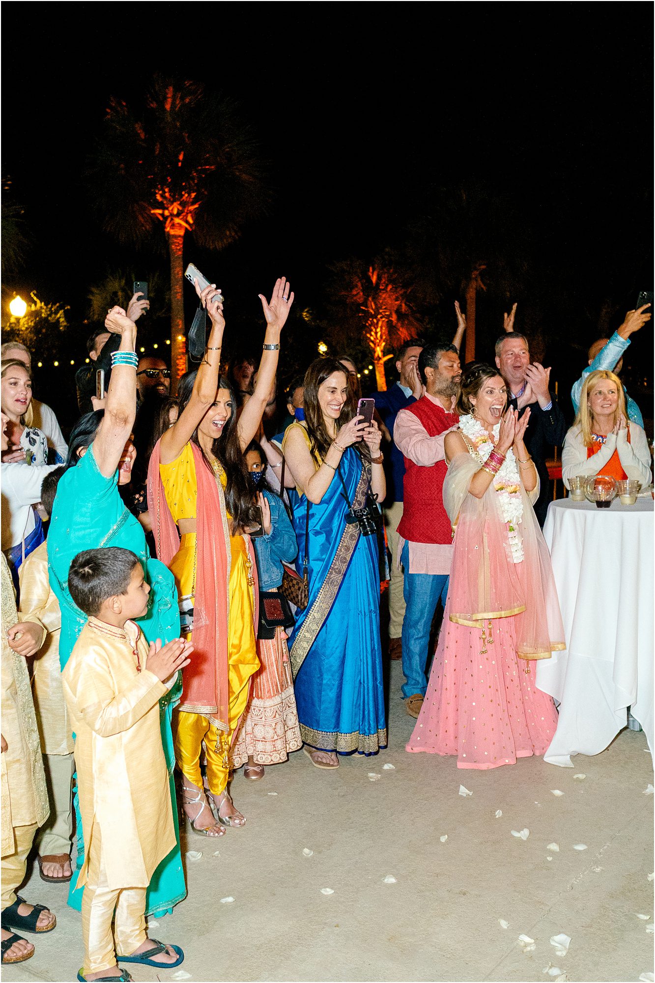 Colorful guests cheering during a lively Indian Florida wedding reception photographed by Catherine Ann Photography