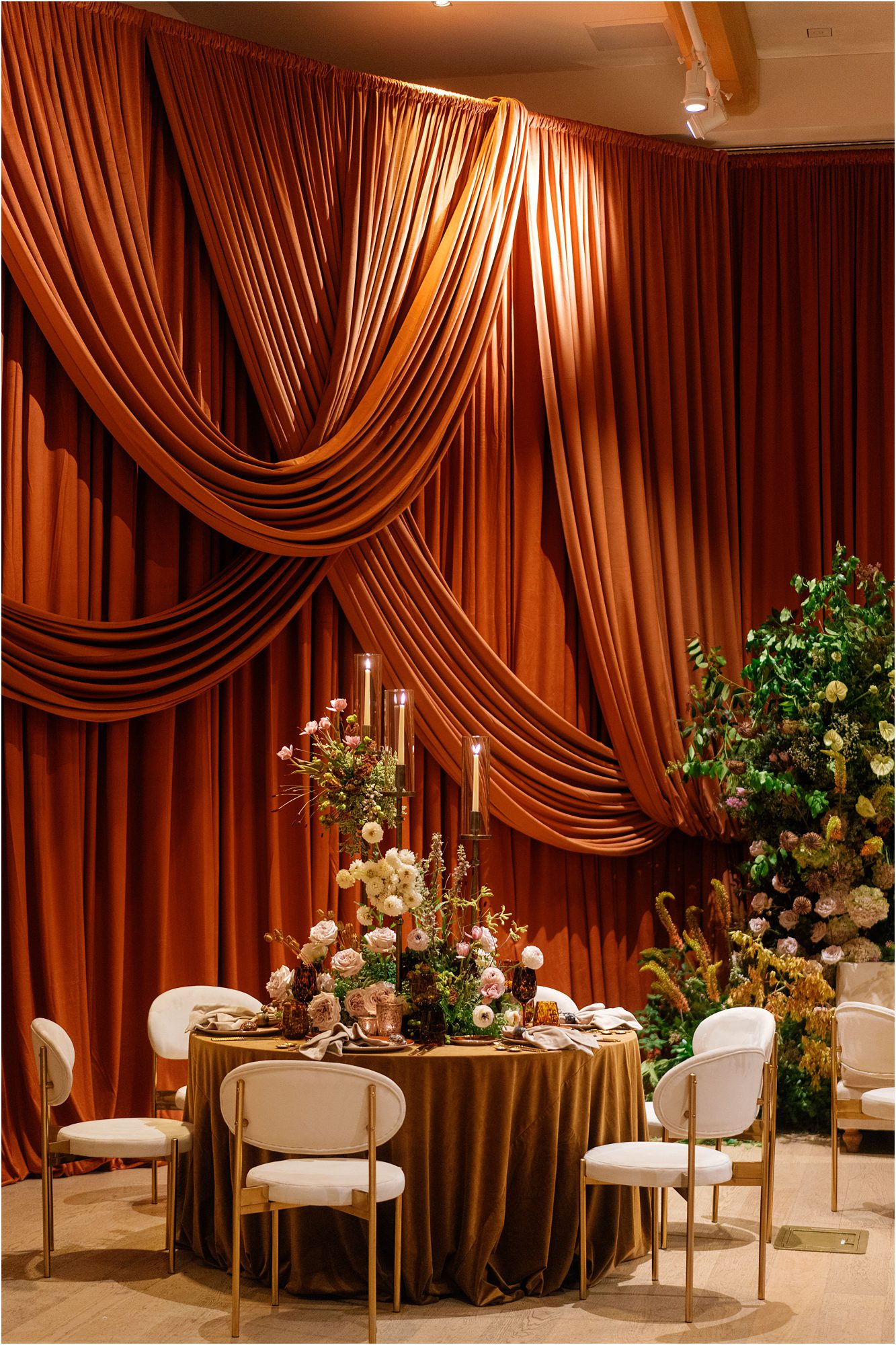 Draped reception space with warm copper fabric, floral arrangements, and candlelight at The Tampa Edition Hotel wedding designed by Parties a la Carte