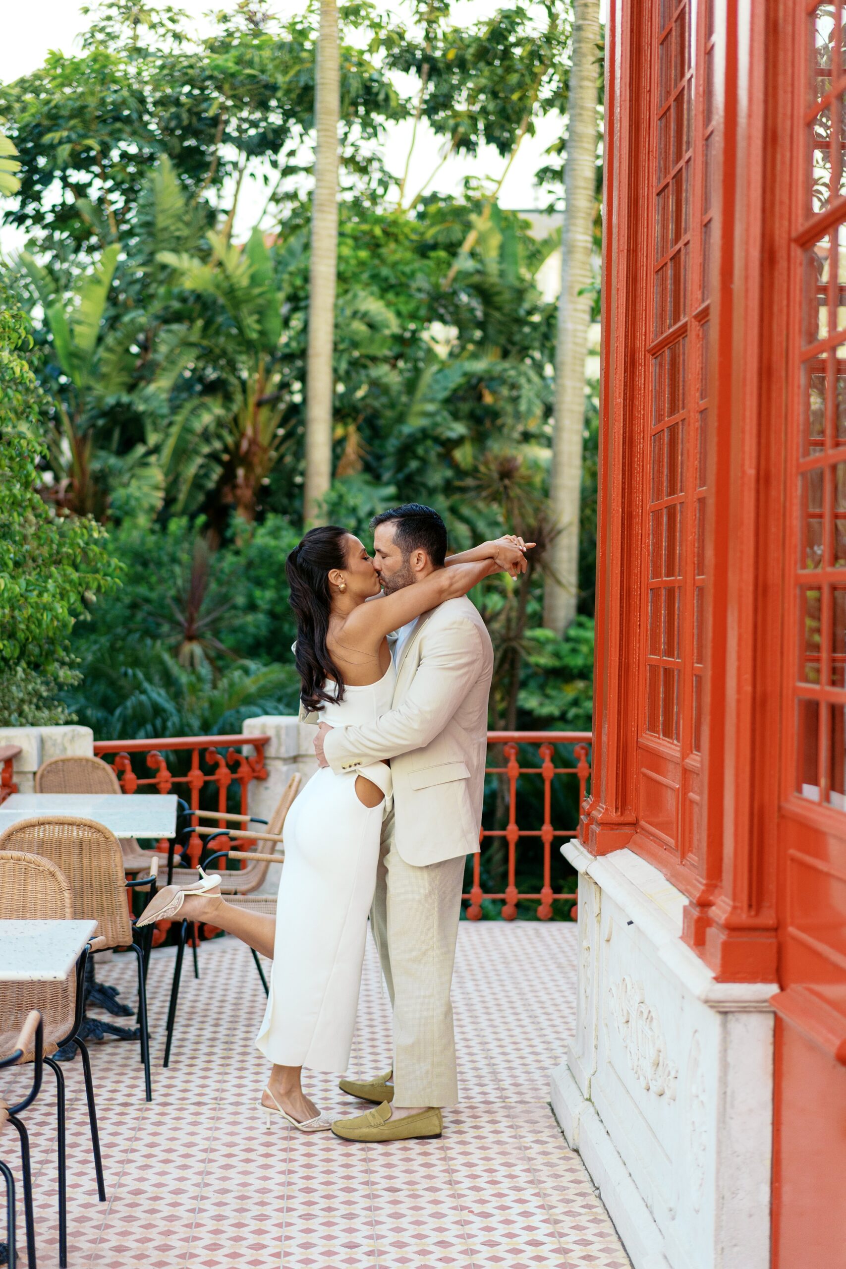 bride and groom kissing at miami wedding with red details