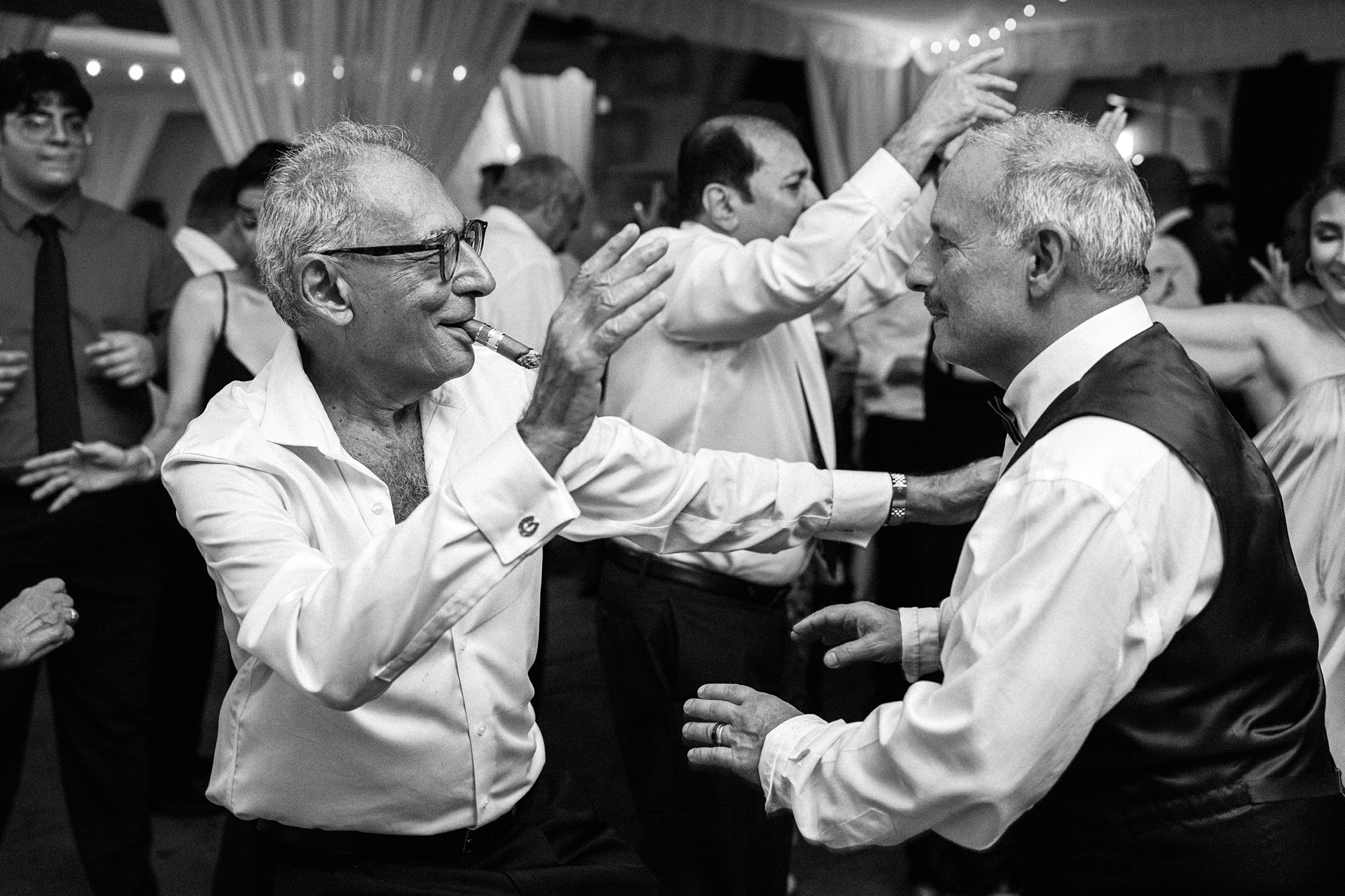 fathers of the bride and groom dancing with cuban cigars at a miami florida wedding