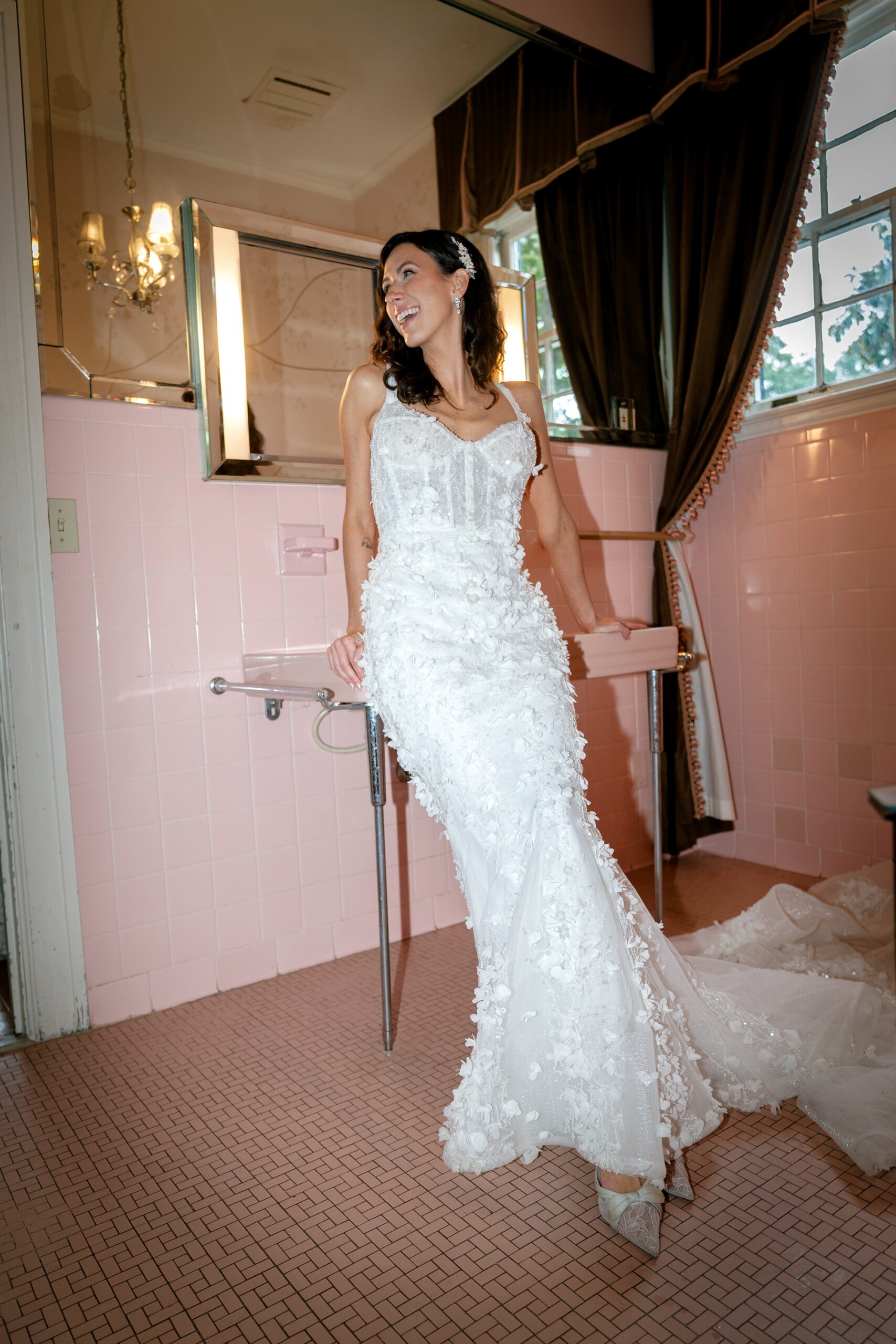 Fashion-forward bride wearing a textured floral wedding dress in a vintage pink bathroom.